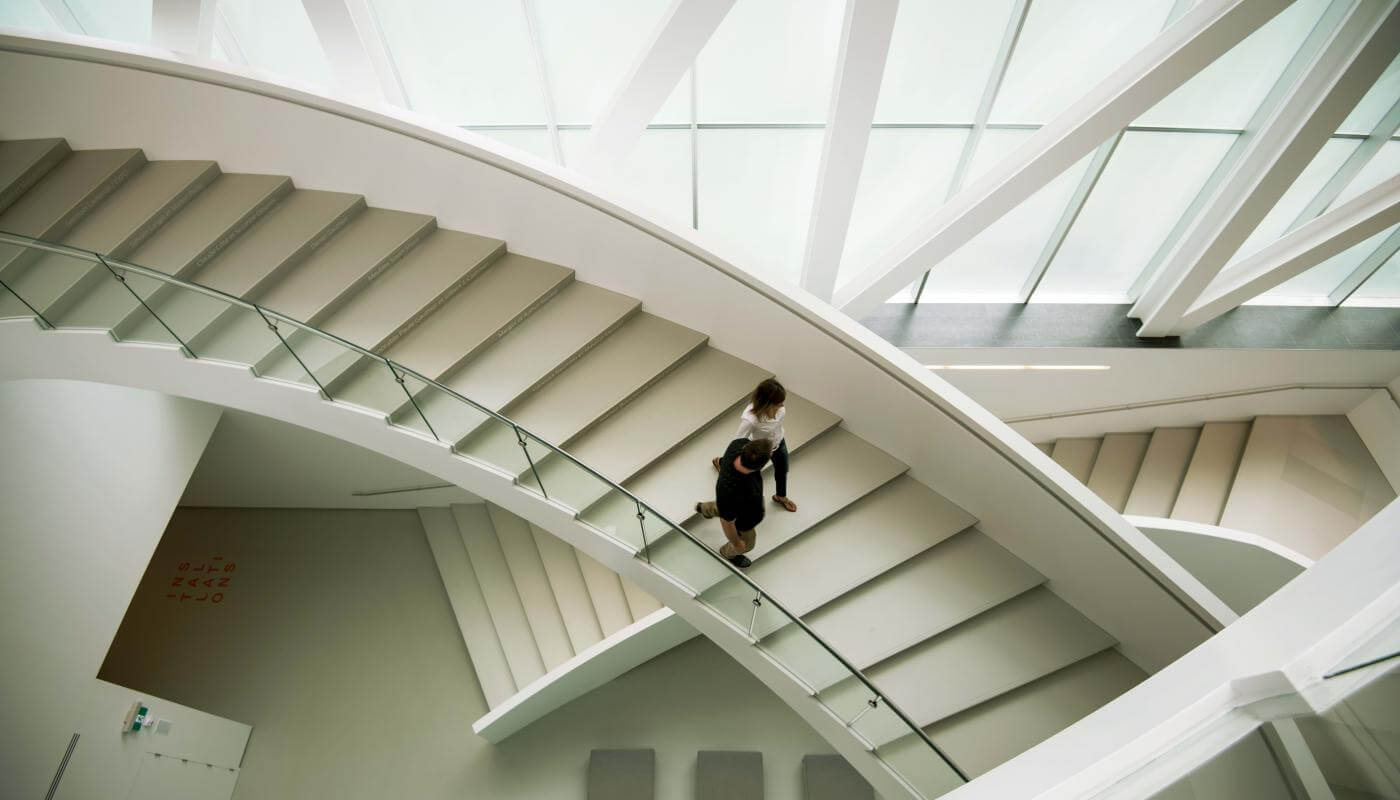 A couple descends the interior staircase of the Pierre Lassonde pavilion at the Musée national des beaux-arts du Québec.