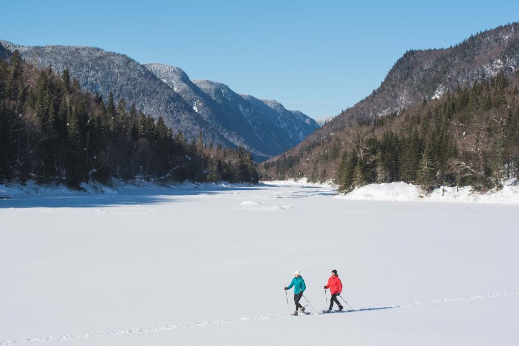 Two girls snowshoeing in the heart of the snow-covered Jacques-Cartier valley, in the Jacques-Cartier national park.