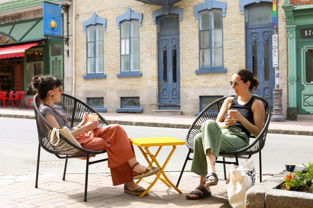 Two girls having a coffee in a pedestrian street