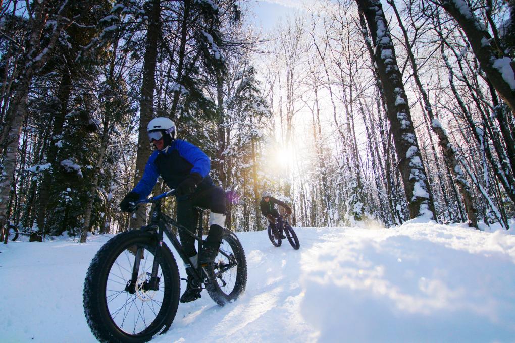 Deux cyclistes en fatbike dans des sentiers enneigés, dans la Vallée Bras-du-Nord.