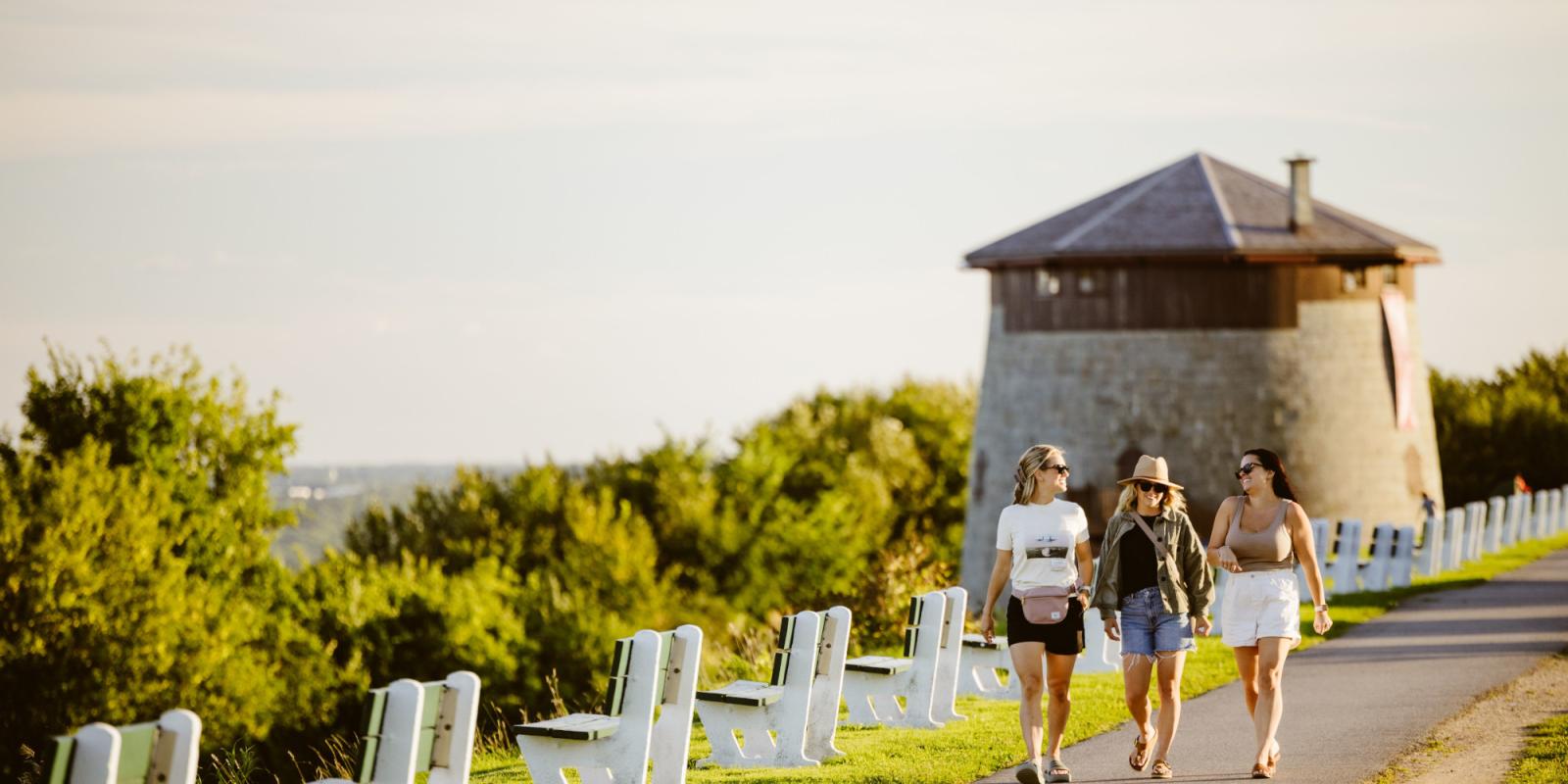 Filles qui marchent sur les plaines devant une tour Martello