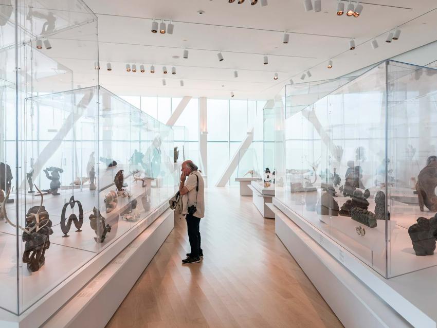 A contemplative man in front of an exhibition window at the Musée national des beaux-arts du Québec.