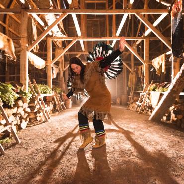 Une danseuse amérindienne performe une danse traditionnelle à l'intérieur de la maison longue à Wendake.